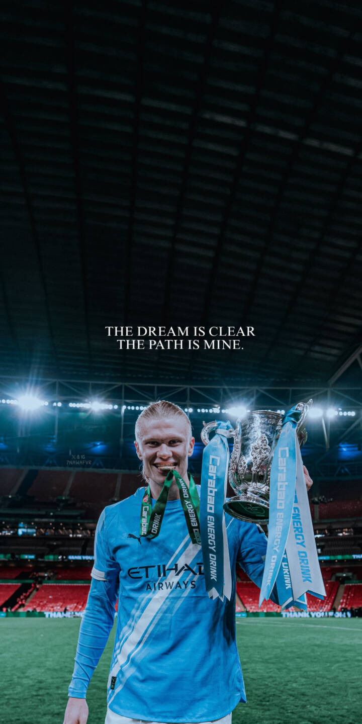 Download this Erling Haaland 4K wallpaper for your iPhone, showcasing his victory. The wallpaper features Haaland holding a trophy with 'The dream is clear. The path is mine' written above him. | football trophy iphone soccer premier league haaland manchester city mobile erling haaland 4k wallpaper hd wallpaper man city Download this Erling Haaland 4K wallpaper for your iPhone, showcasing his victory. The wallpaper features Haaland holding a trophy with 'The dream is clear. The path is mine' written above him.