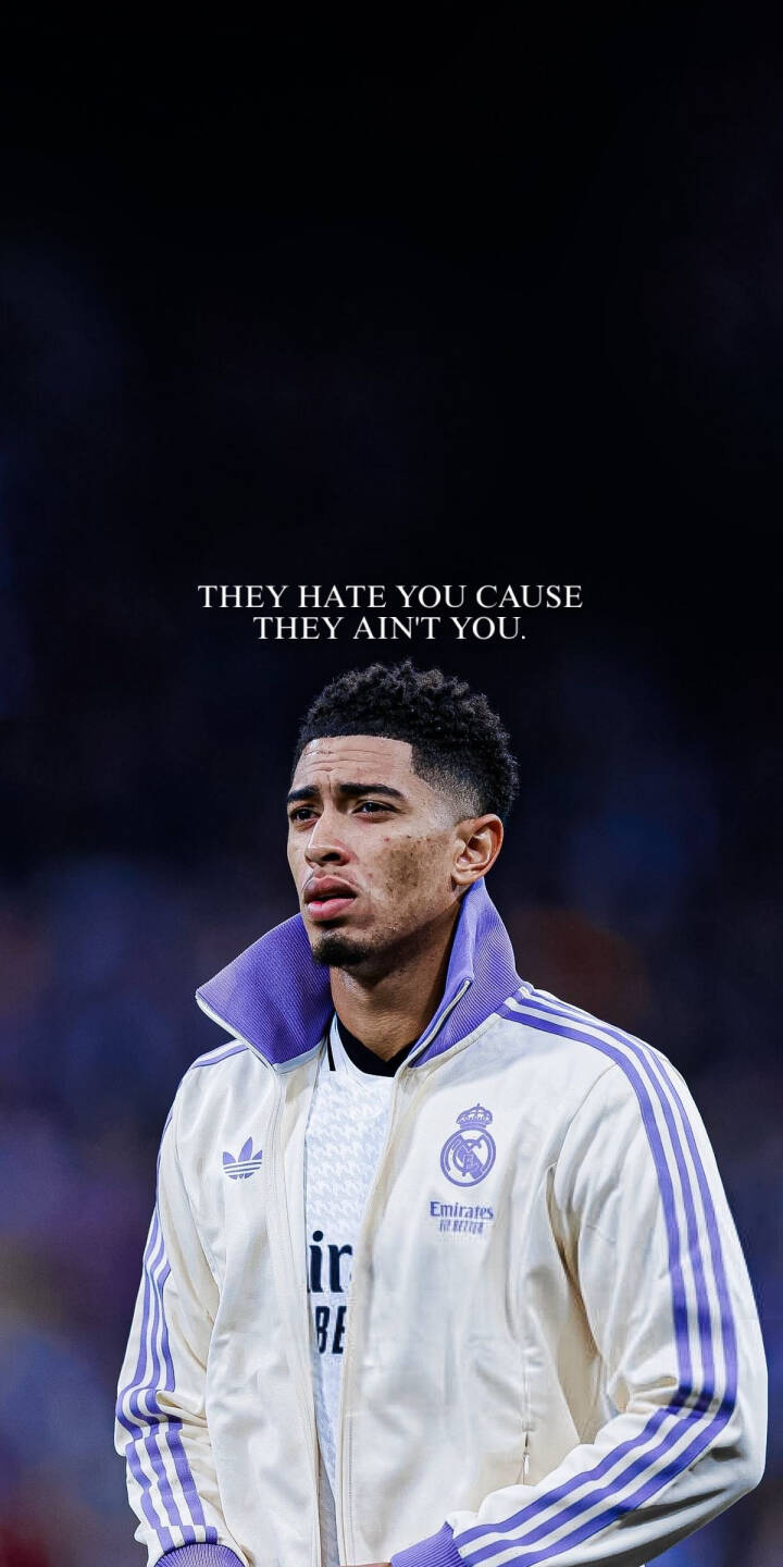 This stunning Jude Bellingham 4K wallpaper captures the football star in his iconic cream and purple Real Madrid jacket, with a motivational quote enhancing the background. Perfect for your iPhone, this high-quality wallpaper showcases his intense focus and the vibrant stadium atmosphere, making it an ideal choice for any fan. | sports football athlete iphone soccer real madrid jude bellingham bellingham mobile 4k wallpaper hd wallpaper los blancos This stunning Jude Bellingham 4K wallpaper captures the football star in his iconic cream and purple Real Madrid jacket, with a motivational quote enhancing the background. Perfect for your iPhone, this high-quality wallpaper showcases his intense focus and the vibrant stadium atmosphere, making it an ideal choice for any fan.