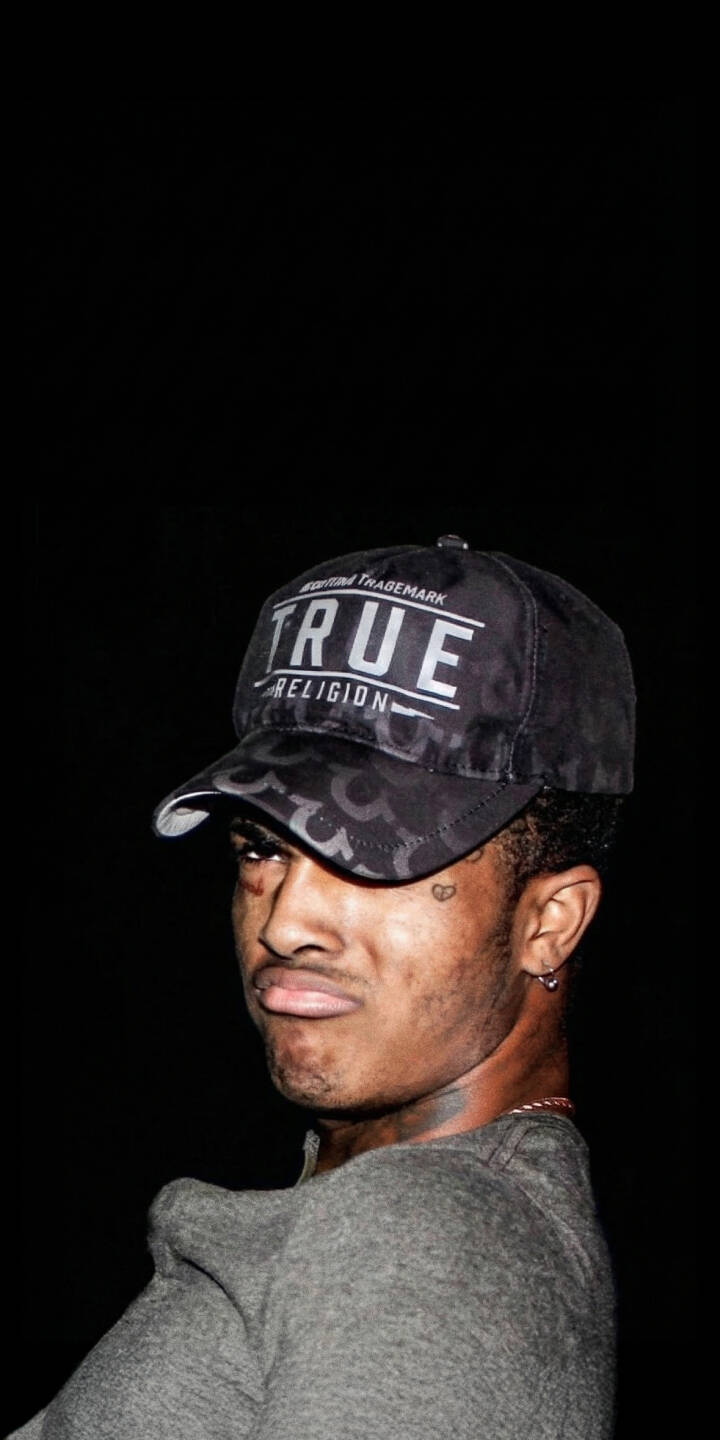 XXXTentacion's intense gaze and visible heart tattoo, framed by a dark background and a bold "TRUE RELIGION" cap, make for a uniquely moody 4K wallpaper. This captivating wallpaper is perfect for any fan looking to personalize their iPhone. | rapper dark portrait xxxtentacion iphone wallpaper hip hop mobile 4k wallpaper hd wallpaper jahseh onfroy true religion XXXTentacion's intense gaze and visible heart tattoo, framed by a dark background and a bold "TRUE RELIGION" cap, make for a uniquely moody 4K wallpaper. This captivating wallpaper is perfect for any fan looking to personalize their iPhone.