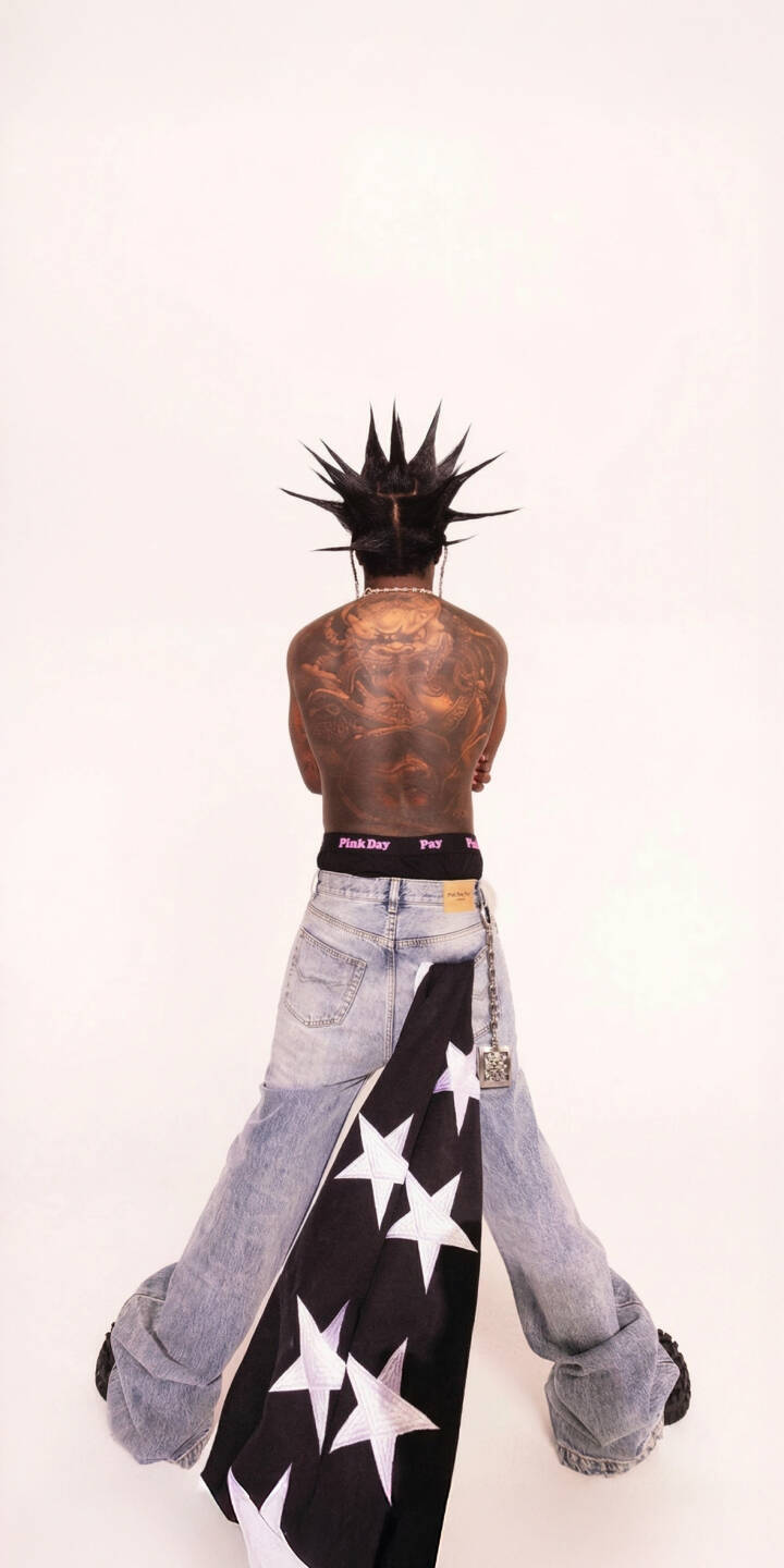 Intricate mythological tattoos stretch across the back of an individual showcasing a bold spiky hairstyle, starkly framed against a white backdrop in this edgy 4K wallpaper. This visually distinct wallpaper, featuring a black star-studded fabric draped with a chain, is ideal for an iPhone. | iphone wallpaper spiky hair mobile 4k wallpaper hd wallpaper streetwear fashion back tattoos punk style artist aesthetic black stars edgy look Intricate mythological tattoos stretch across the back of an individual showcasing a bold spiky hairstyle, starkly framed against a white backdrop in this edgy 4K wallpaper. This visually distinct wallpaper, featuring a black star-studded fabric draped with a chain, is ideal for an iPhone.