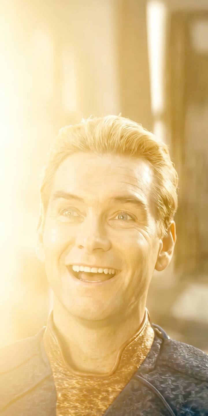 A brilliant golden light bathes Homelander's unsettling wide smile in this striking 4K wallpaper for iPhone, showcasing his piercing blue eyes and iconic uniform details. This radiant wallpaper captures the complex character in a subtly ominous yet visually compelling way. | the boys smile superhero homelander iphone wallpaper tv series mobile 4k wallpaper hd wallpaper golden light radiant A brilliant golden light bathes Homelander's unsettling wide smile in this striking 4K wallpaper for iPhone, showcasing his piercing blue eyes and iconic uniform details. This radiant wallpaper captures the complex character in a subtly ominous yet visually compelling way.