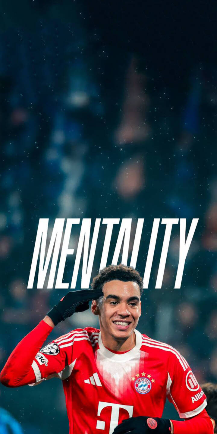 Jamal Musiala flashes a bright smile while giving a salute gesture under the bold 'MENTALITY' text in this inspiring 4K wallpaper. This vibrant wallpaper for your iPhone showcases the Bayern Munich star in his iconic red jersey. | sports football iphone wallpaper mobile mentality 4k wallpaper hd wallpaper musiala jamal musiala bayern munich Jamal Musiala flashes a bright smile while giving a salute gesture under the bold 'MENTALITY' text in this inspiring 4K wallpaper. This vibrant wallpaper for your iPhone showcases the Bayern Munich star in his iconic red jersey.