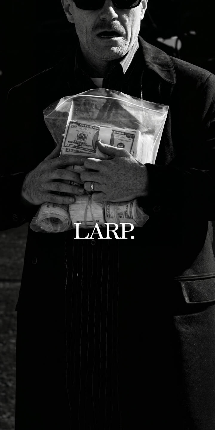 A man in sunglasses and a black clerical collar defiantly clutches a large plastic bag brimming with rolled cash in this gritty black and white 4K wallpaper. This intriguing wallpaper, bearing the text "LARP.", offers a mysterious aesthetic perfect for your iPhone. | aesthetic money crime iphone wallpaper black and white mobile 4k wallpaper hd wallpaper mysterious larp disguise A man in sunglasses and a black clerical collar defiantly clutches a large plastic bag brimming with rolled cash in this gritty black and white 4K wallpaper. This intriguing wallpaper, bearing the text "LARP.", offers a mysterious aesthetic perfect for your iPhone.