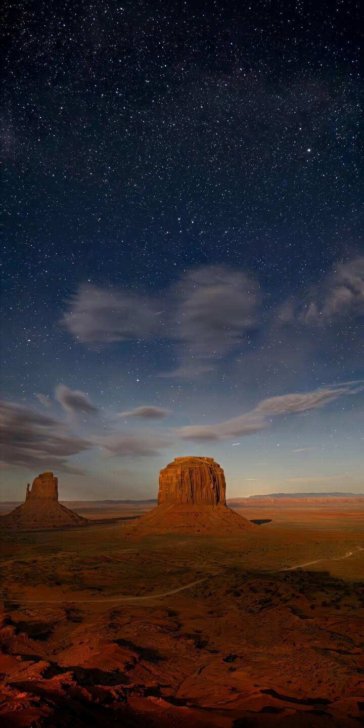 Countless stars glitter vividly across the deep blue night sky over iconic Monument Valley in this breathtaking 4K wallpaper, featuring towering sandstone buttes against the reddish desert terrain—an essential wallpaper for iPhone users seeking celestial landscapes. | landscape night desert iphone nature galaxy stars wallpaper mobile 4k wallpaper hd wallpaper monument valley Countless stars glitter vividly across the deep blue night sky over iconic Monument Valley in this breathtaking 4K wallpaper, featuring towering sandstone buttes against the reddish desert terrain—an essential wallpaper for iPhone users seeking celestial landscapes.