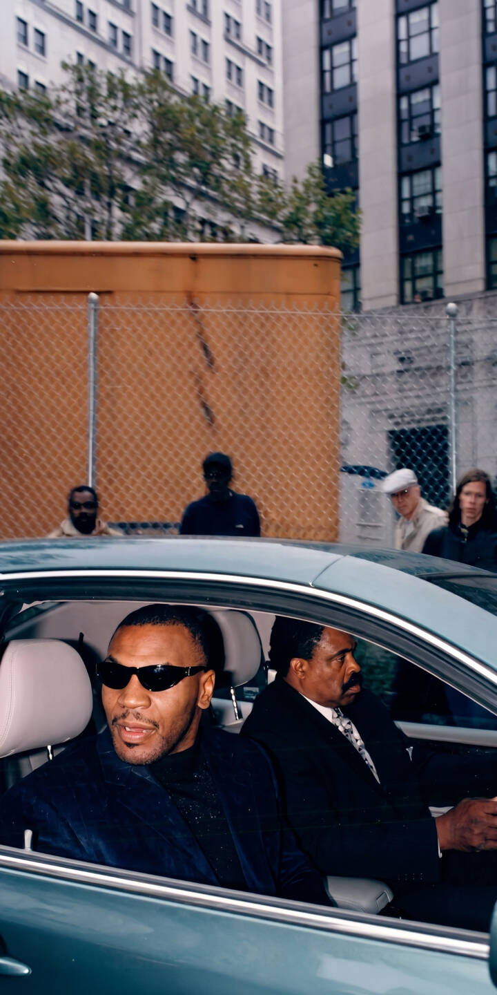 Mike Tyson looks cool in black sunglasses from the passenger seat of a car, passing by city buildings in this compelling 4K wallpaper—a perfect mobile wallpaper for iPhone. This celebrity wallpaper is ideal for fans of the iconic boxer. | city boxer sunglasses boxing iphone wallpaper mobile mike tyson celebrity 4k wallpaper hd wallpaper street photography Mike Tyson looks cool in black sunglasses from the passenger seat of a car, passing by city buildings in this compelling 4K wallpaper—a perfect mobile wallpaper for iPhone. This celebrity wallpaper is ideal for fans of the iconic boxer.