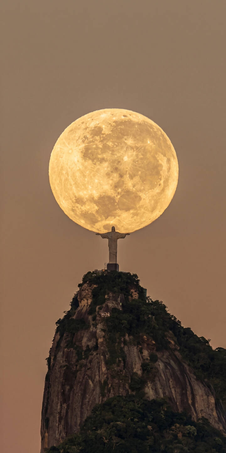 A colossal full moon hovers directly behind the iconic Christ the Redeemer statue, casting a celestial glow over the mountain peak in this breathtaking 4K wallpaper. This stunning vista makes an awe-inspiring wallpaper for your iPhone. | moon statue iphone wallpaper brazil mobile full moon 4k wallpaper hd wallpaper celestial christ the redeemer rio de janeiro A colossal full moon hovers directly behind the iconic Christ the Redeemer statue, casting a celestial glow over the mountain peak in this breathtaking 4K wallpaper. This stunning vista makes an awe-inspiring wallpaper for your iPhone.