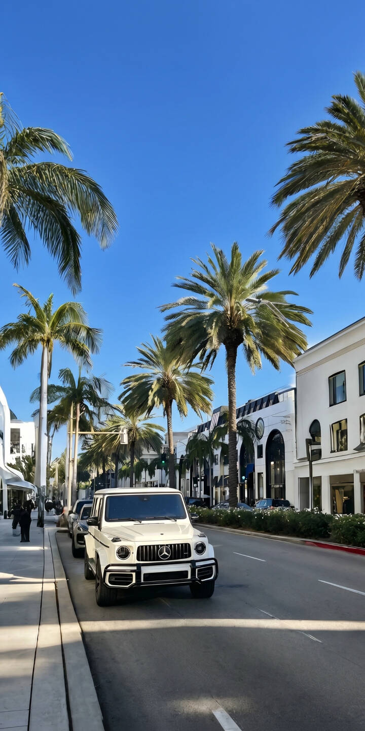 A pristine white Mercedes G-Class gleams under a clear blue sky, parked alongside lush palm trees on a luxurious street, creating a vibrant 4K wallpaper for your iPhone. This striking automotive scene is an ideal high-definition wallpaper for any car enthusiast. | iphone mercedes wallpaper mobile luxury car sunny g-class street palm trees 4k wallpaper hd wallpaper g-wagen A pristine white Mercedes G-Class gleams under a clear blue sky, parked alongside lush palm trees on a luxurious street, creating a vibrant 4K wallpaper for your iPhone. This striking automotive scene is an ideal high-definition wallpaper for any car enthusiast.