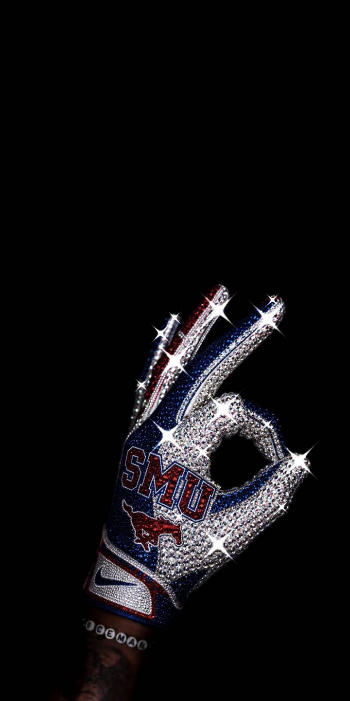 Dazzling diamond studs sparkle across this SMU football glove, flashing brilliant light as it forms an 'OK' gesture, making a stunning 4K wallpaper for iPhone. This eye-catching wallpaper, set against a stark black background, beautifully highlights the iconic SMU logo. | football iphone luxury wallpaper sport mobile 4k wallpaper hd wallpaper sparkle michael jackson diamond glove smu smu mustangs Dazzling diamond studs sparkle across this SMU football glove, flashing brilliant light as it forms an 'OK' gesture, making a stunning 4K wallpaper for iPhone. This eye-catching wallpaper, set against a stark black background, beautifully highlights the iconic SMU logo.