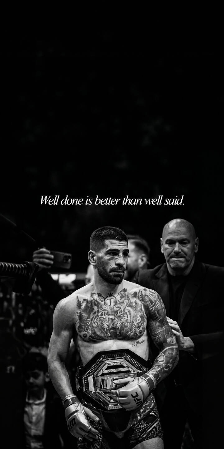 The iconic black and white tone highlights Ilia Topuria proudly holding his UFC championship belt, creating a powerful 4K wallpaper; intricate tattoos adorn his chest, complementing the motivational quote "Well done is better than well said" at the top of this dynamic iPhone wallpaper. | motivational iphone wallpaper black and white mma mobile ufc 4k wallpaper hd wallpaper tattoos championship belt ilia topuria The iconic black and white tone highlights Ilia Topuria proudly holding his UFC championship belt, creating a powerful 4K wallpaper; intricate tattoos adorn his chest, complementing the motivational quote "Well done is better than well said" at the top of this dynamic iPhone wallpaper.