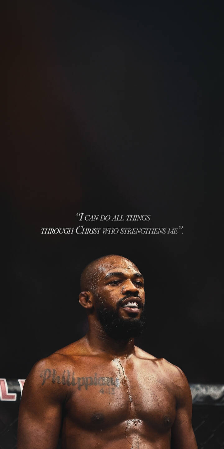 Jon Jones' determined gaze and glistening sweat are front and center in this powerful 4K wallpaper, illuminated by the iconic "I CAN DO ALL THINGS THROUGH CHRIST WHO STRENGTHENS ME" verse floating above him. This inspirational wallpaper for iPhone also highlights his "Philippians 4:13" chest tattoo, making it a compelling mobile background. | iphone wallpaper mma mobile ufc bible verse 4k wallpaper hd wallpaper dark aesthetic inspirational jon jones bones jones Jon Jones' determined gaze and glistening sweat are front and center in this powerful 4K wallpaper, illuminated by the iconic "I CAN DO ALL THINGS THROUGH CHRIST WHO STRENGTHENS ME" verse floating above him. This inspirational wallpaper for iPhone also highlights his "Philippians 4:13" chest tattoo, making it a compelling mobile background.
