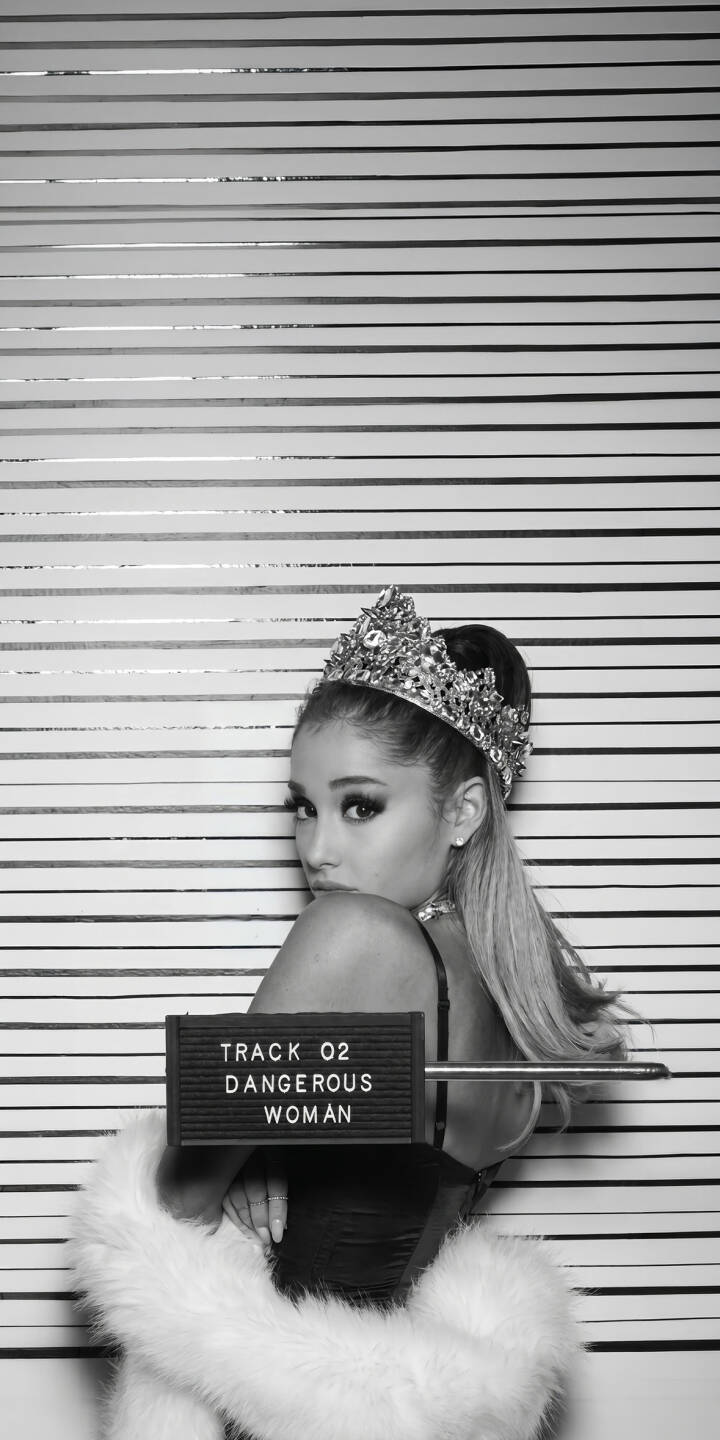 Ariana Grande gazes playfully over her shoulder, adorned with a dazzling crown and a luxurious white fur wrap, making for a striking 4K wallpaper. This iconic Dangerous Woman photo is a stunning wallpaper for any iPhone user. | crown iphone wallpaper black and white mobile ariana grande celebrity 4k wallpaper hd wallpaper glamorous dangerous woman pop singer Ariana Grande gazes playfully over her shoulder, adorned with a dazzling crown and a luxurious white fur wrap, making for a striking 4K wallpaper. This iconic Dangerous Woman photo is a stunning wallpaper for any iPhone user.