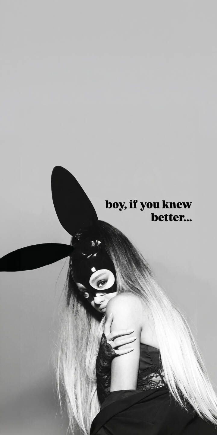 Ariana Grande's piercing gaze meets the viewer through her iconic black bunny mask, creating a striking monochrome aesthetic in this alluring 4K wallpaper for iPhone. The mysterious mood is enhanced by the subtle lace details and the quote 'boy, if you knew better...' making this a captivating wallpaper. | iphone pop wallpaper black and white mobile ariana grande 4k wallpaper hd wallpaper grande dangerous woman bunny mask sultry Ariana Grande's piercing gaze meets the viewer through her iconic black bunny mask, creating a striking monochrome aesthetic in this alluring 4K wallpaper for iPhone. The mysterious mood is enhanced by the subtle lace details and the quote 'boy, if you knew better...' making this a captivating wallpaper.