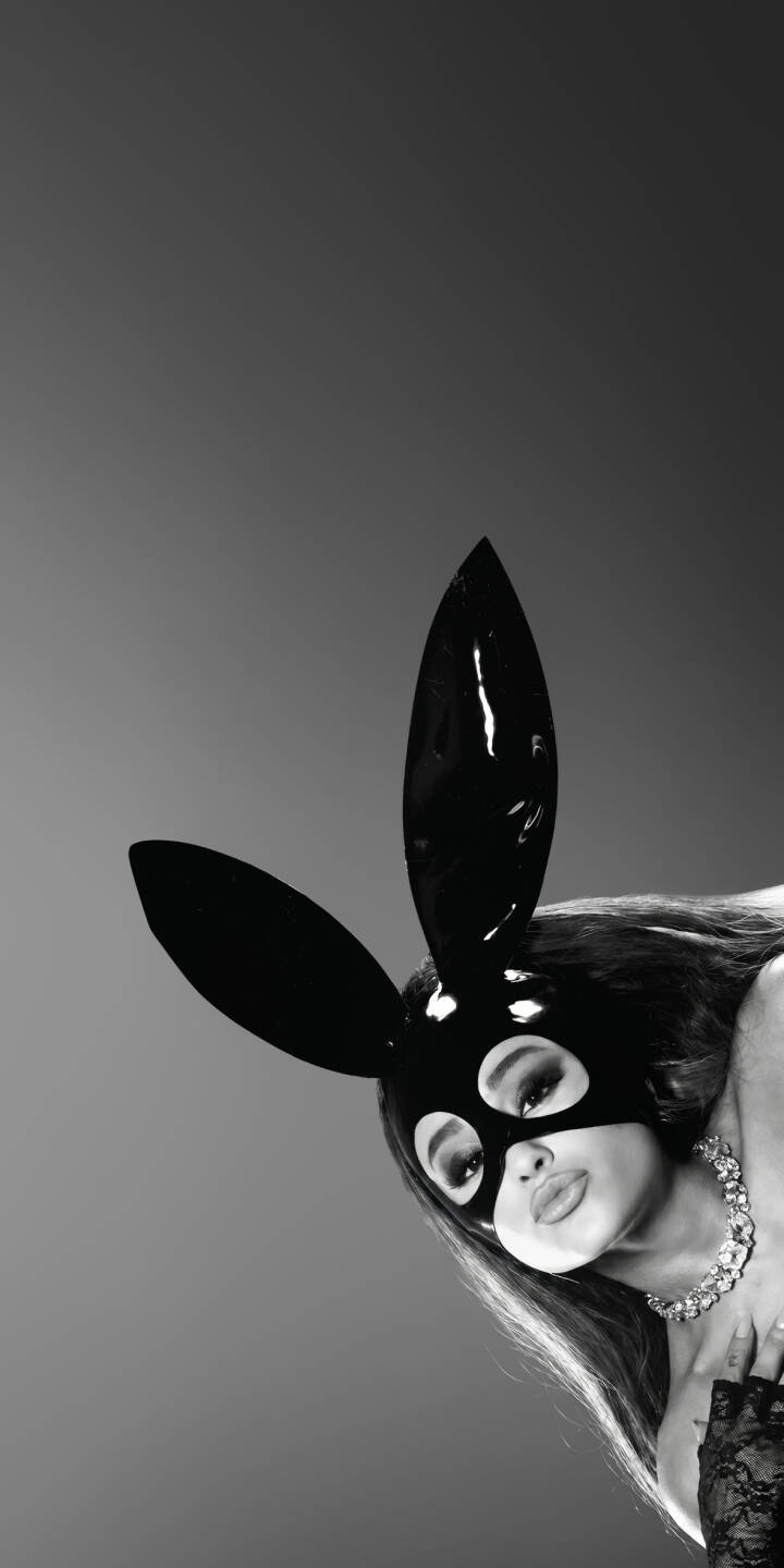 Ariana Grande's iconic black bunny mask shines with a glossy finish as she peers subtly in this captivating black and white 4K wallpaper. A sparkling necklace and elegant lace glove complete the alluring aesthetic, making this a must-have wallpaper for iPhone users. | iphone wallpaper black and white mobile ariana grande celebrity 4k wallpaper hd wallpaper pop star ariana dangerous woman bunny mask Ariana Grande's iconic black bunny mask shines with a glossy finish as she peers subtly in this captivating black and white 4K wallpaper. A sparkling necklace and elegant lace glove complete the alluring aesthetic, making this a must-have wallpaper for iPhone users.