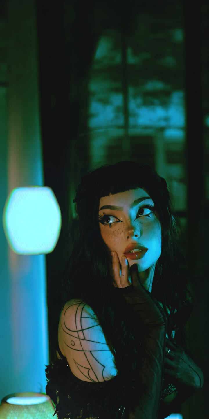A striking cyan light bathes the goth-style adorned face of this mysterious girl, her thoughtful gaze and intricate eye makeup standing out in this stunning 4K wallpaper — an essential aesthetic wallpaper for your iPhone. | aesthetic iphone wallpaper mobile moody 4k wallpaper hd wallpaper dark aesthetic cyan light emo girl gothic girl alt girl A striking cyan light bathes the goth-style adorned face of this mysterious girl, her thoughtful gaze and intricate eye makeup standing out in this stunning 4K wallpaper — an essential aesthetic wallpaper for your iPhone.
