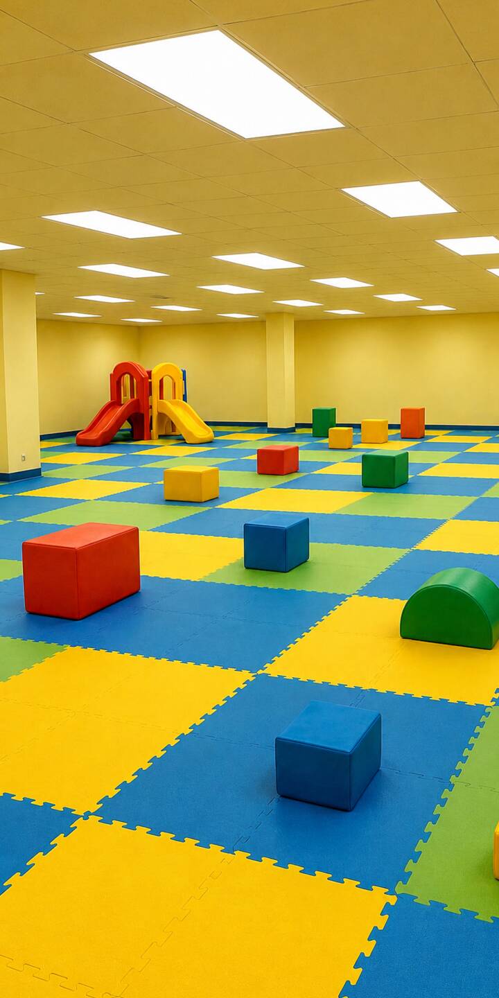 A vibrant expanse of blue, yellow, and green checkered mats covers the floor of this expansive 4K playroom, filled with colorful soft blocks and illuminated by bright ceiling lights, making it an engaging wallpaper for your iPhone. | colorful iphone wallpaper checkered bright mobile empty 4k wallpaper hd wallpaper liminal space playroom soft play A vibrant expanse of blue, yellow, and green checkered mats covers the floor of this expansive 4K playroom, filled with colorful soft blocks and illuminated by bright ceiling lights, making it an engaging wallpaper for your iPhone.
