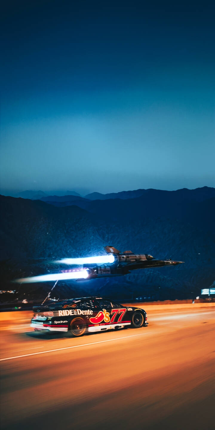Bright blue jet exhaust streams behind a sleek black race car with "Chili's" and #77 logos, creating a dramatic 4K wallpaper with warm road reflections against dark mountains. This dynamic night scene is a perfect wallpaper for iPhone users seeking unique sci-fi racing visuals. | night race car jet iphone wallpaper racing speed futuristic mobile 4k wallpaper hd wallpaper sci-fi Bright blue jet exhaust streams behind a sleek black race car with "Chili's" and #77 logos, creating a dramatic 4K wallpaper with warm road reflections against dark mountains. This dynamic night scene is a perfect wallpaper for iPhone users seeking unique sci-fi racing visuals.