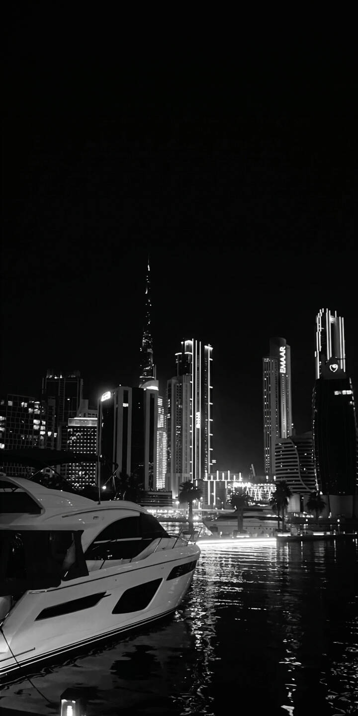 Striking city lights illuminate the iconic Burj Khalifa, reflected subtly on the dark water, forming a dramatic 4K black and white wallpaper that features a luxurious yacht docked in the foreground. This sophisticated urban scene makes a stunning mobile wallpaper for iPhone. | night yacht iphone luxury wallpaper black and white mobile 4k wallpaper hd wallpaper dubai cityscape burj khalifa Striking city lights illuminate the iconic Burj Khalifa, reflected subtly on the dark water, forming a dramatic 4K black and white wallpaper that features a luxurious yacht docked in the foreground. This sophisticated urban scene makes a stunning mobile wallpaper for iPhone.