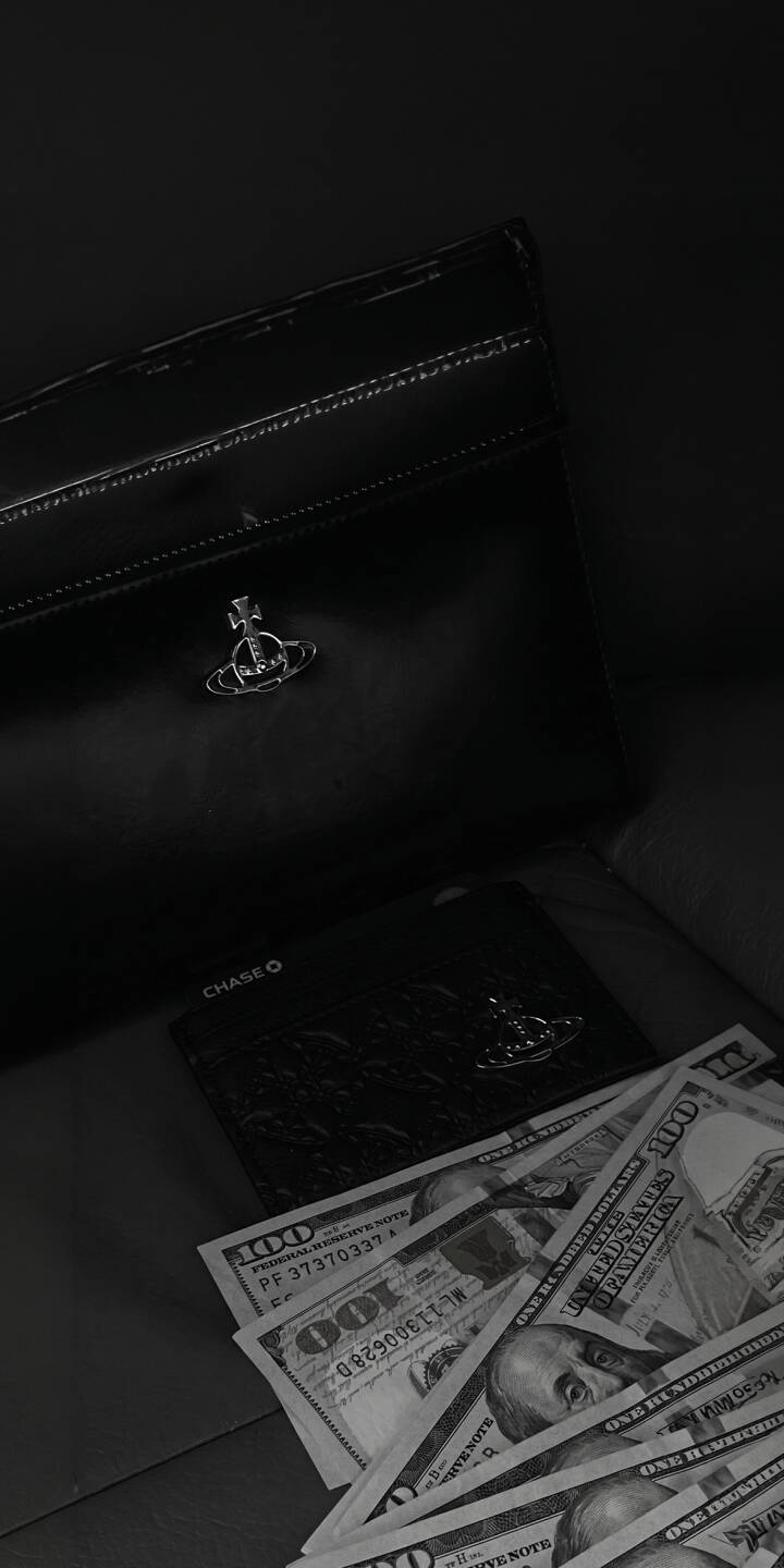 A glossy black Vivienne Westwood bag showcases its iconic orb emblem alongside scattered $100 bills, creating a luxurious and dark aesthetic in this 4K wallpaper. This opulent designer wallpaper for iPhone is a stylish statement, making it a perfect mobile wallpaper choice. | cash money iphone luxury wallpaper mobile 4k wallpaper hd wallpaper dark aesthetic designer vivienne westwood wallet A glossy black Vivienne Westwood bag showcases its iconic orb emblem alongside scattered $100 bills, creating a luxurious and dark aesthetic in this 4K wallpaper. This opulent designer wallpaper for iPhone is a stylish statement, making it a perfect mobile wallpaper choice.