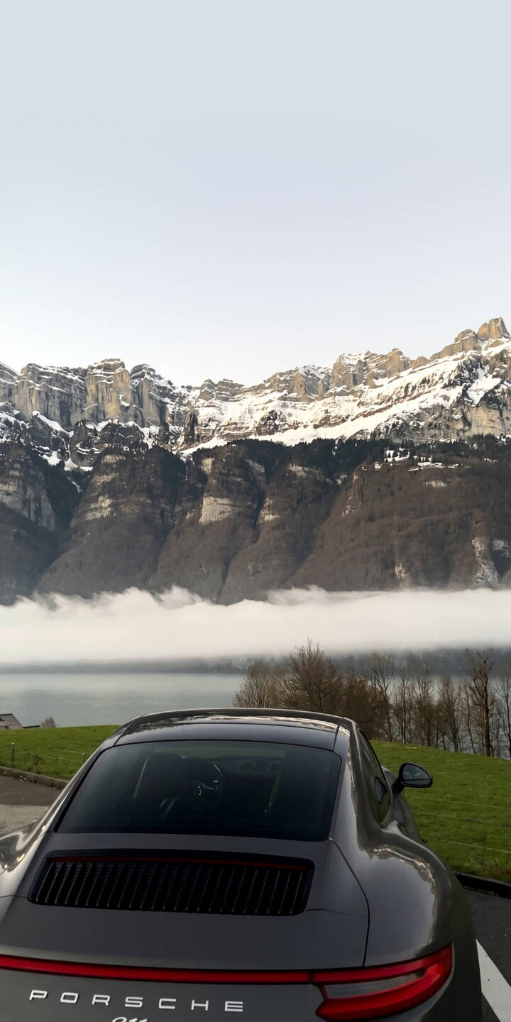 Snow-capped mountains rise majestically above a low-lying fog, framing the sleek grey rear of a Porsche 911 in this stunning 4K wallpaper. It's an epic scenic wallpaper perfect for your iPhone. | foggy iphone porsche mountains wallpaper mobile luxury car porsche 911 4k wallpaper hd wallpaper automotive scenic Snow-capped mountains rise majestically above a low-lying fog, framing the sleek grey rear of a Porsche 911 in this stunning 4K wallpaper. It's an epic scenic wallpaper perfect for your iPhone.