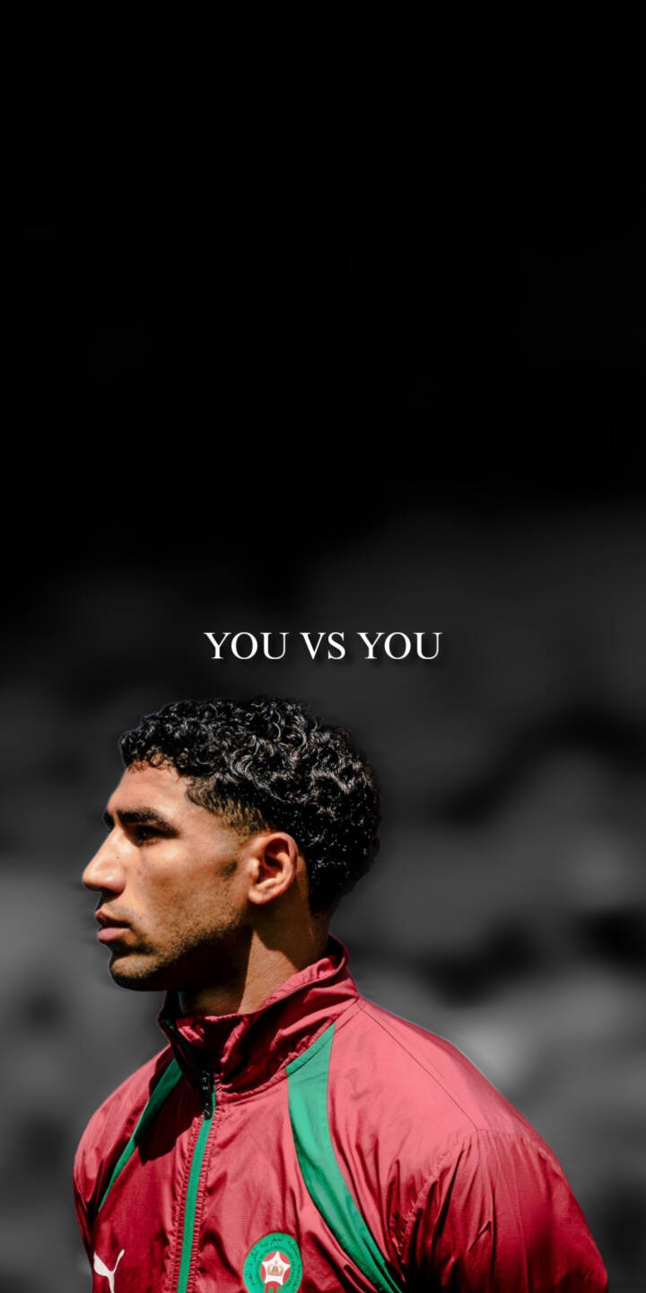 The powerful quote 'YOU VS YOU' hovers above a focused Moroccan footballer, captured in a profile shot wearing his team's red and green jersey against a dark background in this striking 4K wallpaper. This inspirational wallpaper is perfect for any iPhone to motivate and uplift. | sports athlete motivational iphone soccer wallpaper mobile footballer 4k wallpaper hd wallpaper moroccan inspirational hakimi The powerful quote 'YOU VS YOU' hovers above a focused Moroccan footballer, captured in a profile shot wearing his team's red and green jersey against a dark background in this striking 4K wallpaper. This inspirational wallpaper is perfect for any iPhone to motivate and uplift.