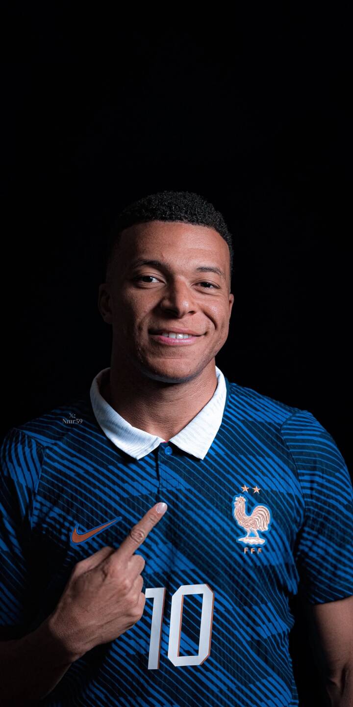 Kylian Mbappé flashes a warm smile while pointing at his France number 10 jersey in this captivating 4K wallpaper, making it a perfect sports wallpaper for iPhone users. | sports football athlete iphone mbappe soccer wallpaper mobile 4k wallpaper hd wallpaper kylian mbappe france kit Kylian Mbappé flashes a warm smile while pointing at his France number 10 jersey in this captivating 4K wallpaper, making it a perfect sports wallpaper for iPhone users.