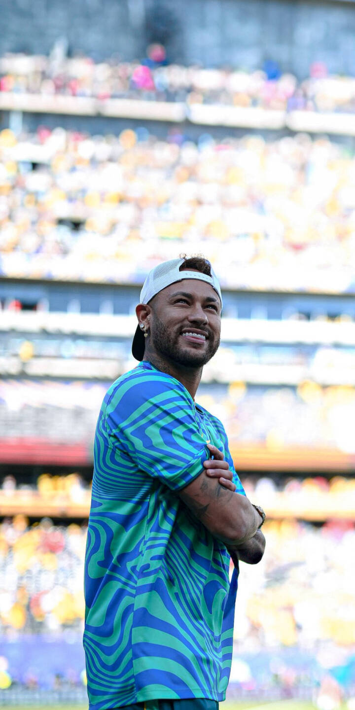 Neymar's radiant smile lights up this vibrant 4K wallpaper as he poses with arms crossed, wearing a distinctive blue and green patterned shirt against a lively stadium backdrop. This stunning wallpaper is perfect for personalizing your iPhone. | sports football stadium smile iphone soccer wallpaper neymar mobile 4k wallpaper hd wallpaper neymar jr Neymar's radiant smile lights up this vibrant 4K wallpaper as he poses with arms crossed, wearing a distinctive blue and green patterned shirt against a lively stadium backdrop. This stunning wallpaper is perfect for personalizing your iPhone.