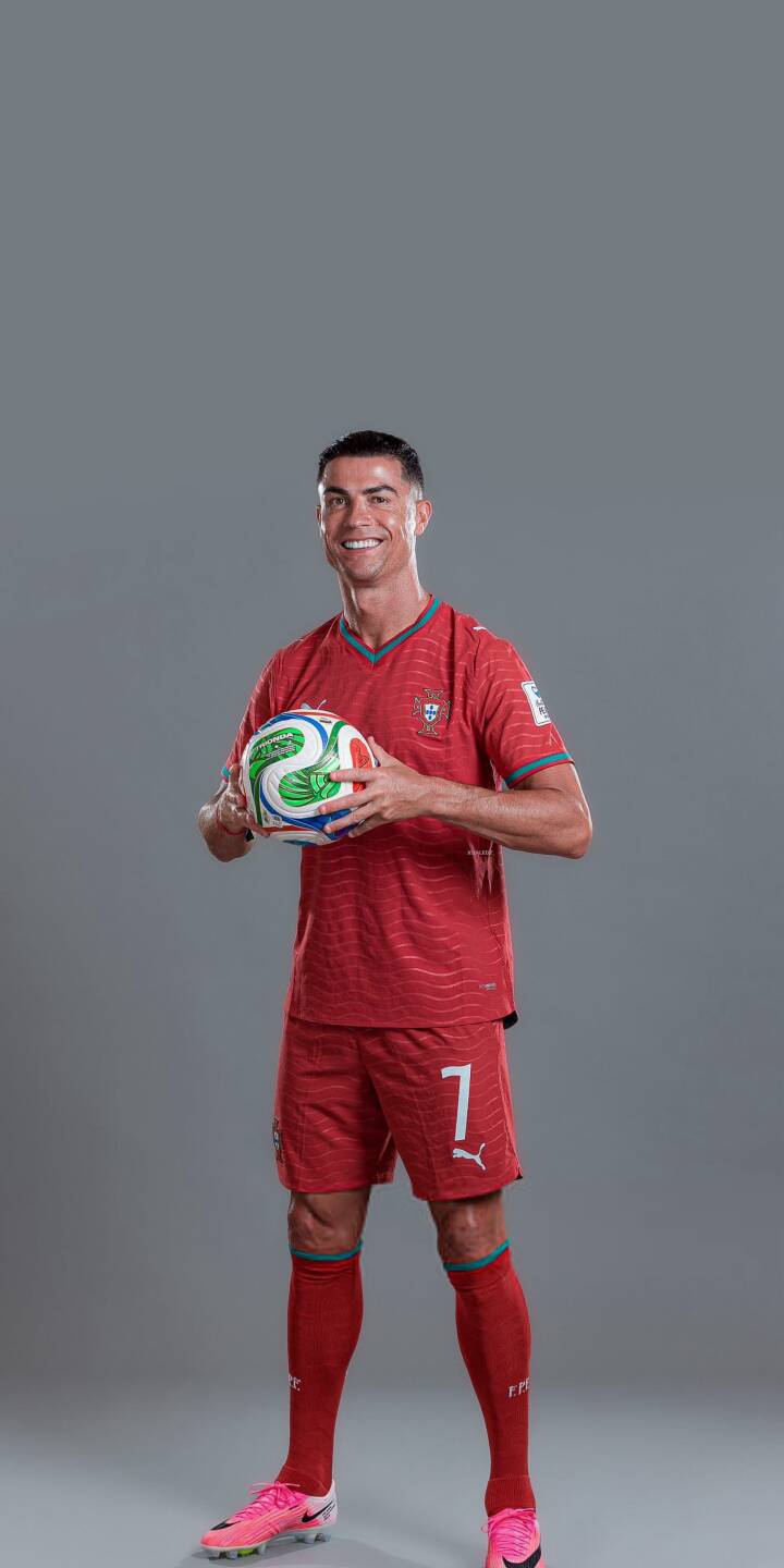 Cristiano Ronaldo flashes a wide, confident smile, proudly holding a vibrant multicolored football in his iconic red Portugal kit in this stunning 4K wallpaper. This dynamic portrait makes an excellent wallpaper for iPhone users looking to celebrate the legendary CR7. | football player iphone ronaldo soccer wallpaper cr7 cristiano ronaldo mobile 4k wallpaper hd wallpaper portugal jersey Cristiano Ronaldo flashes a wide, confident smile, proudly holding a vibrant multicolored football in his iconic red Portugal kit in this stunning 4K wallpaper. This dynamic portrait makes an excellent wallpaper for iPhone users looking to celebrate the legendary CR7.