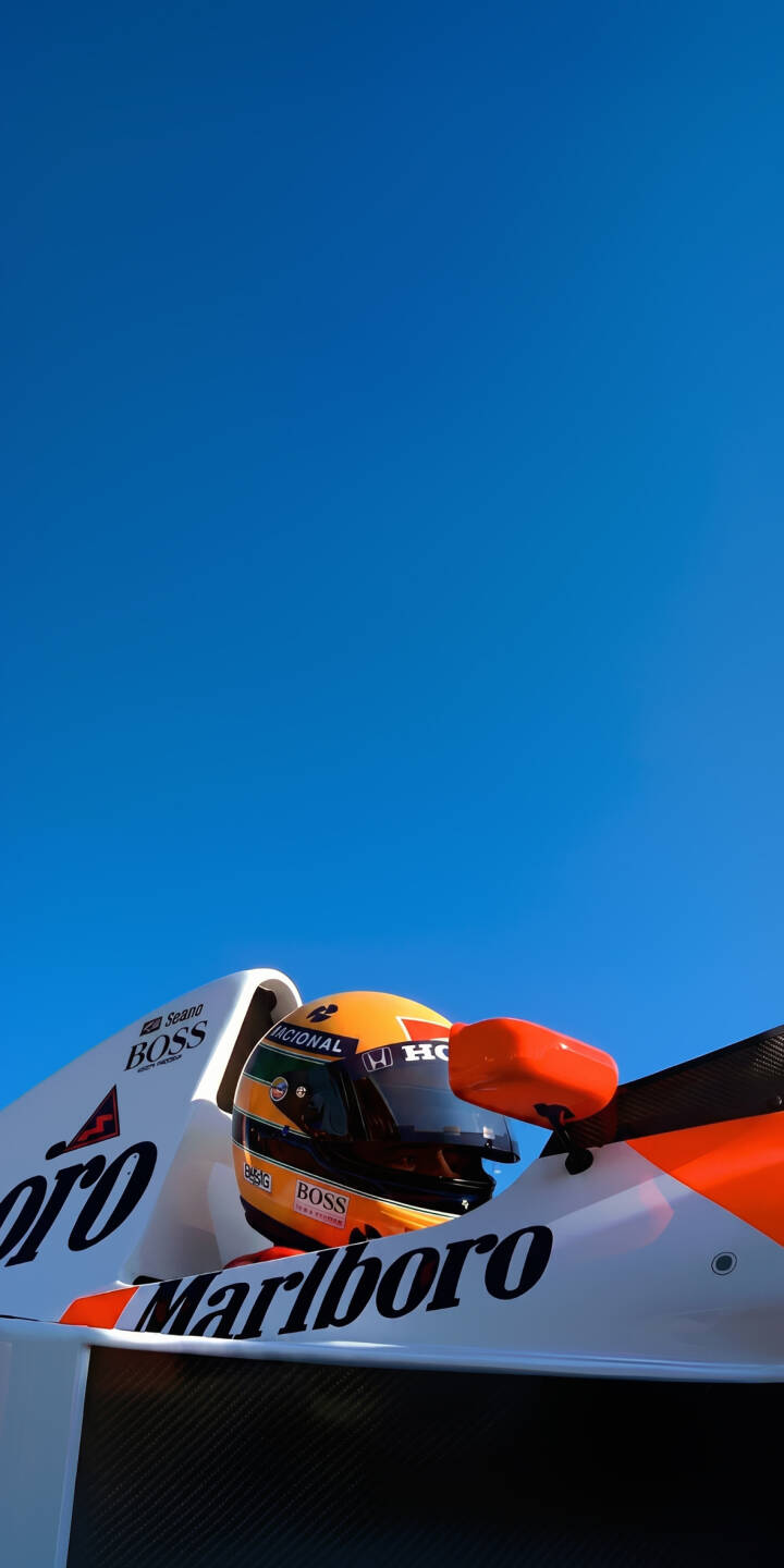 Ayrton Senna's iconic yellow helmet shines brightly against a clear blue sky as he's captured in his legendary McLaren-Honda F1 car in this stunning 4K wallpaper. This high-resolution wallpaper is perfect for any motorsport fan looking for an iconic F1 driver wallpaper on their iPhone. | helmet iphone mclaren wallpaper f1 racing ayrton senna formula 1 mobile 4k wallpaper hd wallpaper senna Ayrton Senna's iconic yellow helmet shines brightly against a clear blue sky as he's captured in his legendary McLaren-Honda F1 car in this stunning 4K wallpaper. This high-resolution wallpaper is perfect for any motorsport fan looking for an iconic F1 driver wallpaper on their iPhone.