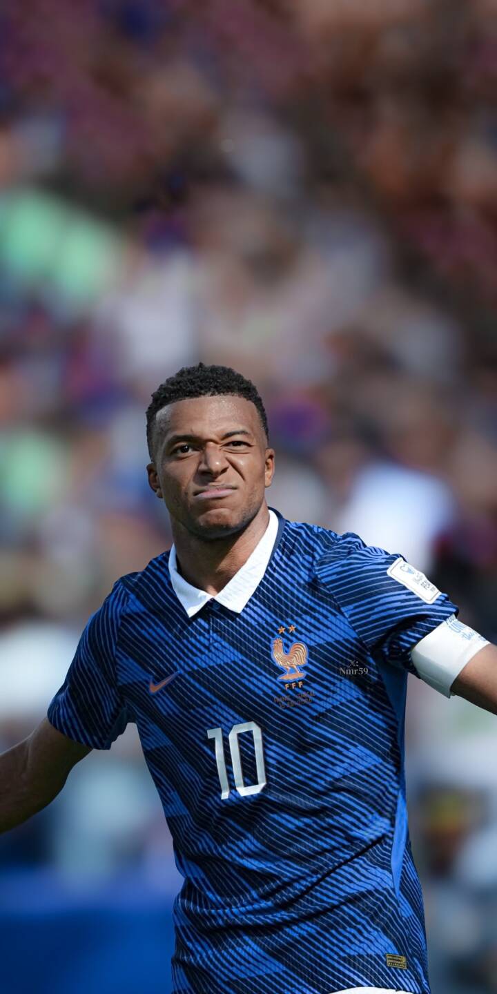 Kylian Mbappé displays a determined, intense expression while wearing his iconic blue France number 10 jersey in this vivid 4K wallpaper, making it an excellent wallpaper for any iPhone fan. The blurred stadium background keeps focus squarely on the football superstar. | sports football athlete iphone france mbappe soccer wallpaper mobile 4k wallpaper hd wallpaper kylian mbappe Kylian Mbappé displays a determined, intense expression while wearing his iconic blue France number 10 jersey in this vivid 4K wallpaper, making it an excellent wallpaper for any iPhone fan. The blurred stadium background keeps focus squarely on the football superstar.