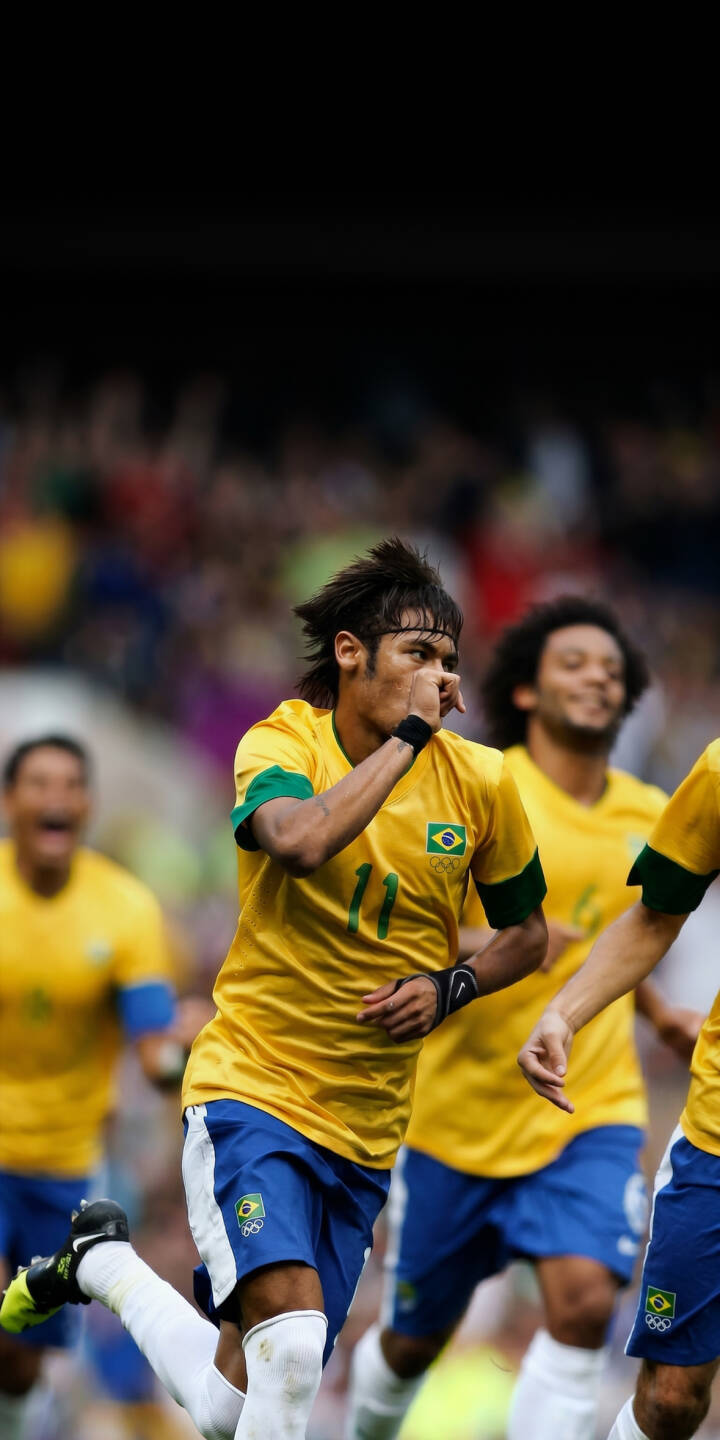 Neymar raises his hand to his mouth in an iconic goal celebration, captured in this vibrant 4K wallpaper for iPhone. This energetic wallpaper showcases the football superstar in his yellow Brazil jersey with the number 11. | sports football celebration iphone soccer wallpaper brazil neymar mobile 4k wallpaper hd wallpaper neymar jr Neymar raises his hand to his mouth in an iconic goal celebration, captured in this vibrant 4K wallpaper for iPhone. This energetic wallpaper showcases the football superstar in his yellow Brazil jersey with the number 11.