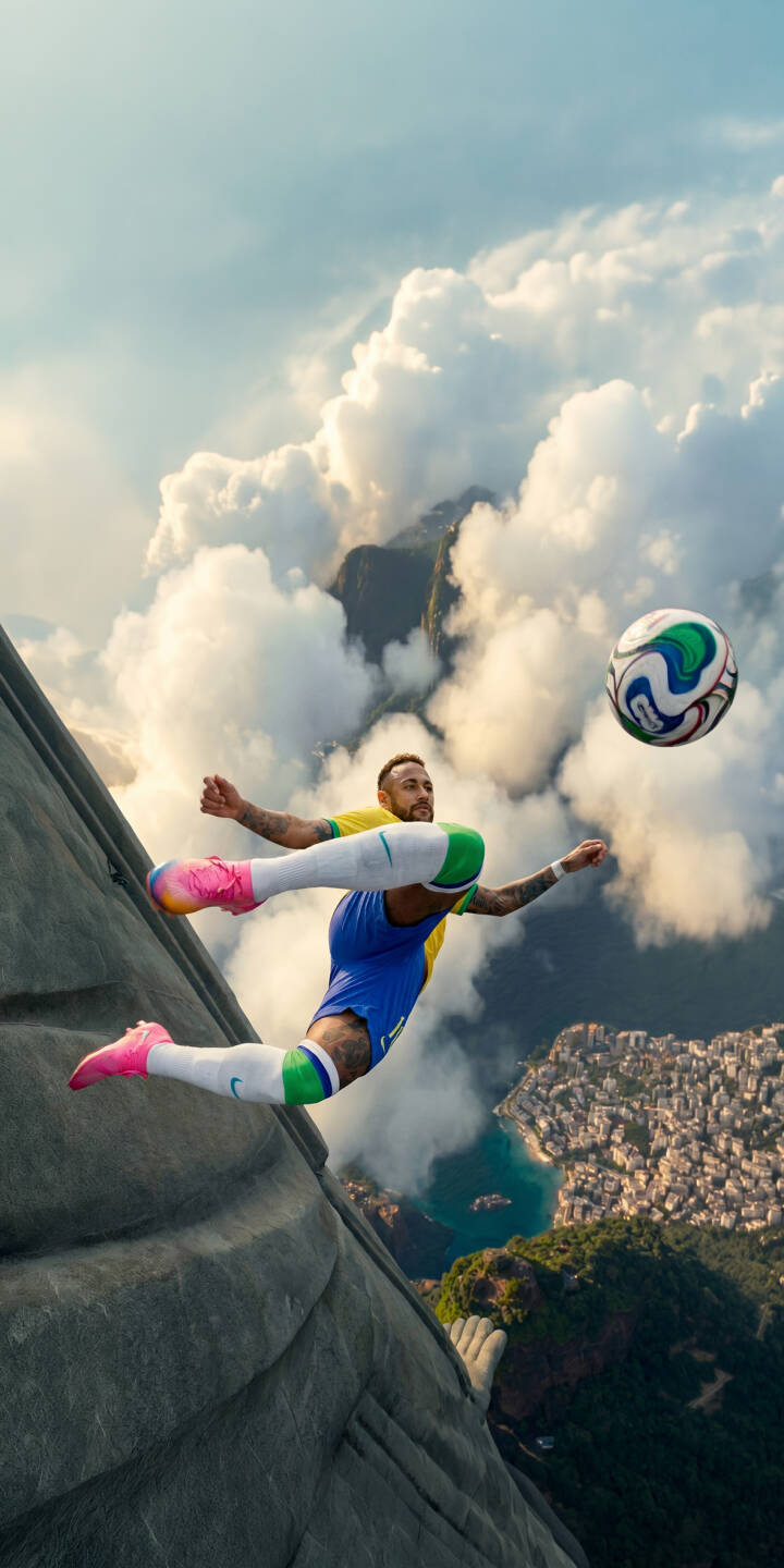 Neymar Jr. dramatically kicks a vibrant soccer ball while suspended in the clouds high above a sprawling city, creating an epic 4K wallpaper for your iPhone. This dynamic football wallpaper showcases his iconic Brazil kit and bright pink shoes, making it a spectacular display. | sports football iphone soccer wallpaper brazil neymar mobile 4k wallpaper hd wallpaper epic neymar jr Neymar Jr. dramatically kicks a vibrant soccer ball while suspended in the clouds high above a sprawling city, creating an epic 4K wallpaper for your iPhone. This dynamic football wallpaper showcases his iconic Brazil kit and bright pink shoes, making it a spectacular display.