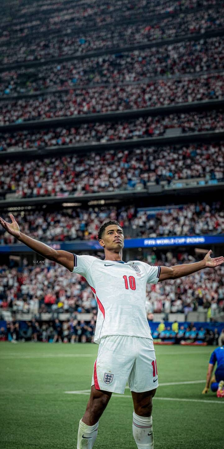 Jude Bellingham stands triumphant on the pitch, arms wide, soaking in the roar of the packed stadium crowd while sporting his iconic white England kit with the number 10. This stunning 4K wallpaper for iPhone perfectly captures his moment of glory, making it an epic mobile wallpaper for any football fan. | football stadium celebration iphone soccer wallpaper jude bellingham mobile 4k wallpaper hd wallpaper three lions england football Jude Bellingham stands triumphant on the pitch, arms wide, soaking in the roar of the packed stadium crowd while sporting his iconic white England kit with the number 10. This stunning 4K wallpaper for iPhone perfectly captures his moment of glory, making it an epic mobile wallpaper for any football fan.