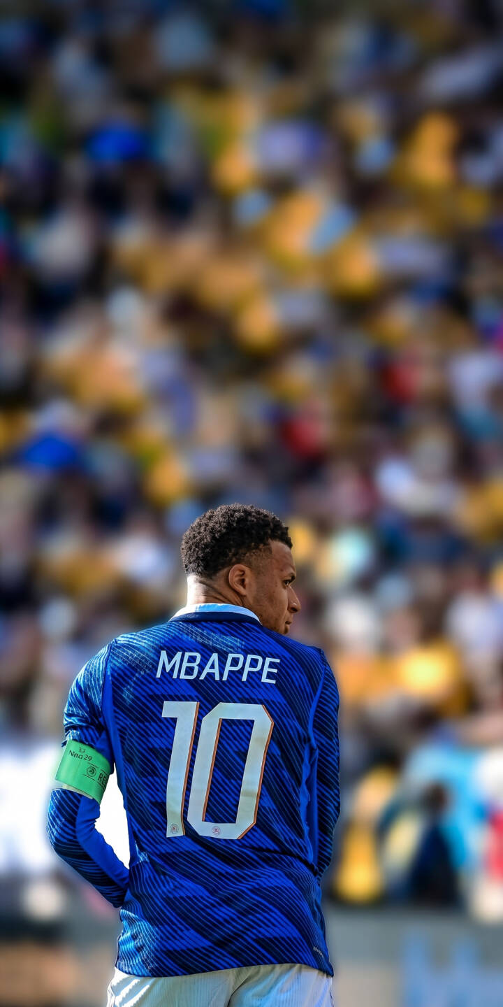 Kylian Mbappé's iconic blue France jersey, number 10, stands out as he looks over his shoulder against a blurred stadium crowd, making this a powerful 4K football wallpaper for iPhone. This vibrant wallpaper captures the star player in a compelling, candid moment. | football iphone mbappe soccer wallpaper mobile 4k wallpaper hd wallpaper sports aesthetic kylian mbappe stadium crowd france jersey Kylian Mbappé's iconic blue France jersey, number 10, stands out as he looks over his shoulder against a blurred stadium crowd, making this a powerful 4K football wallpaper for iPhone. This vibrant wallpaper captures the star player in a compelling, candid moment.