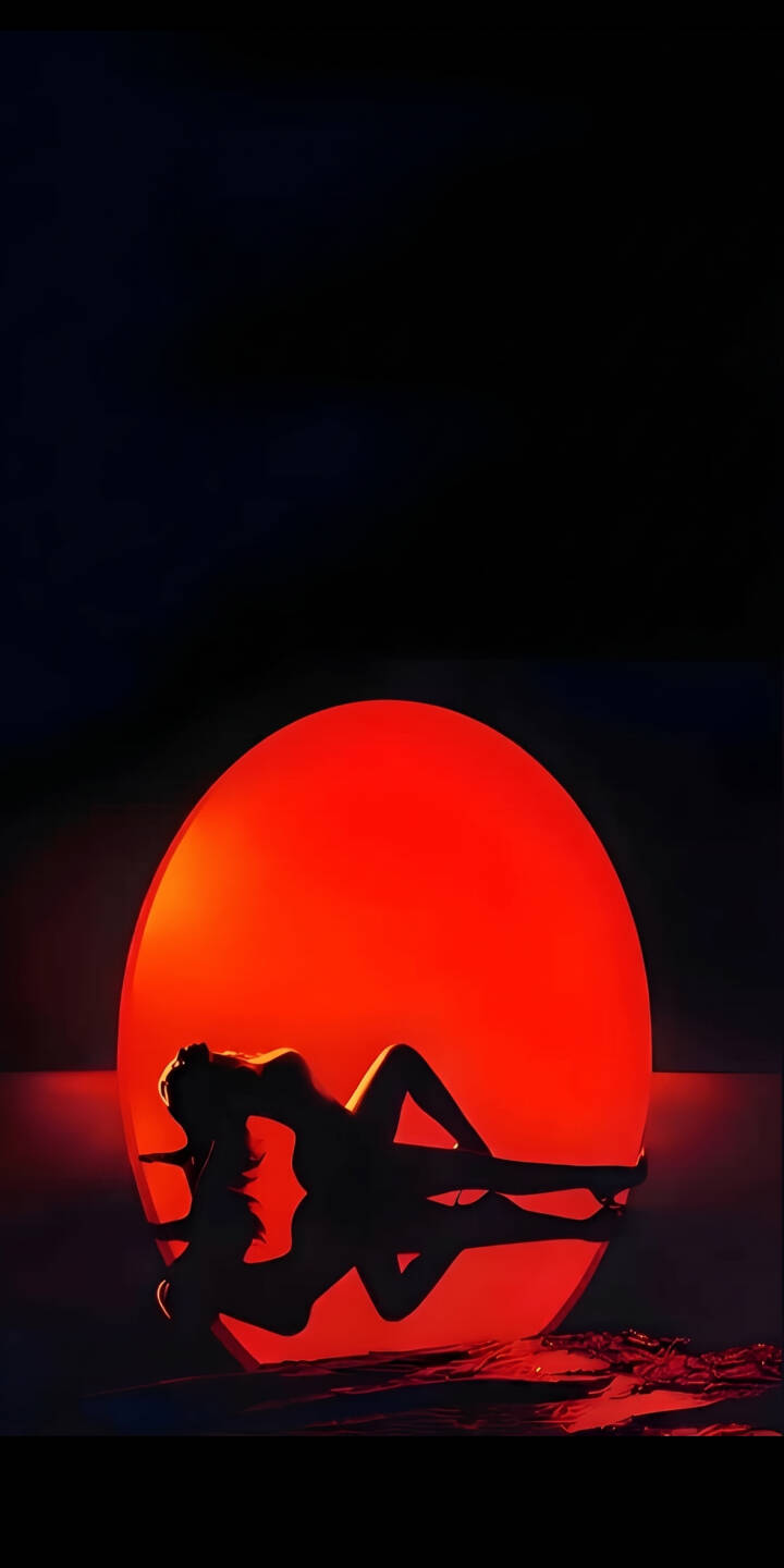 An intense red glowing orb illuminates the dark, creating a dramatic backdrop for the elegant silhouette of a reclining woman and her subtle reflection in this stunning 4K wallpaper. This atmospheric wallpaper is perfect for personalizing your iPhone with a unique, minimalist aesthetic. | aesthetic woman red iphone minimalist wallpaper silhouette artistic mobile glowing 4k wallpaper hd wallpaper An intense red glowing orb illuminates the dark, creating a dramatic backdrop for the elegant silhouette of a reclining woman and her subtle reflection in this stunning 4K wallpaper. This atmospheric wallpaper is perfect for personalizing your iPhone with a unique, minimalist aesthetic.
