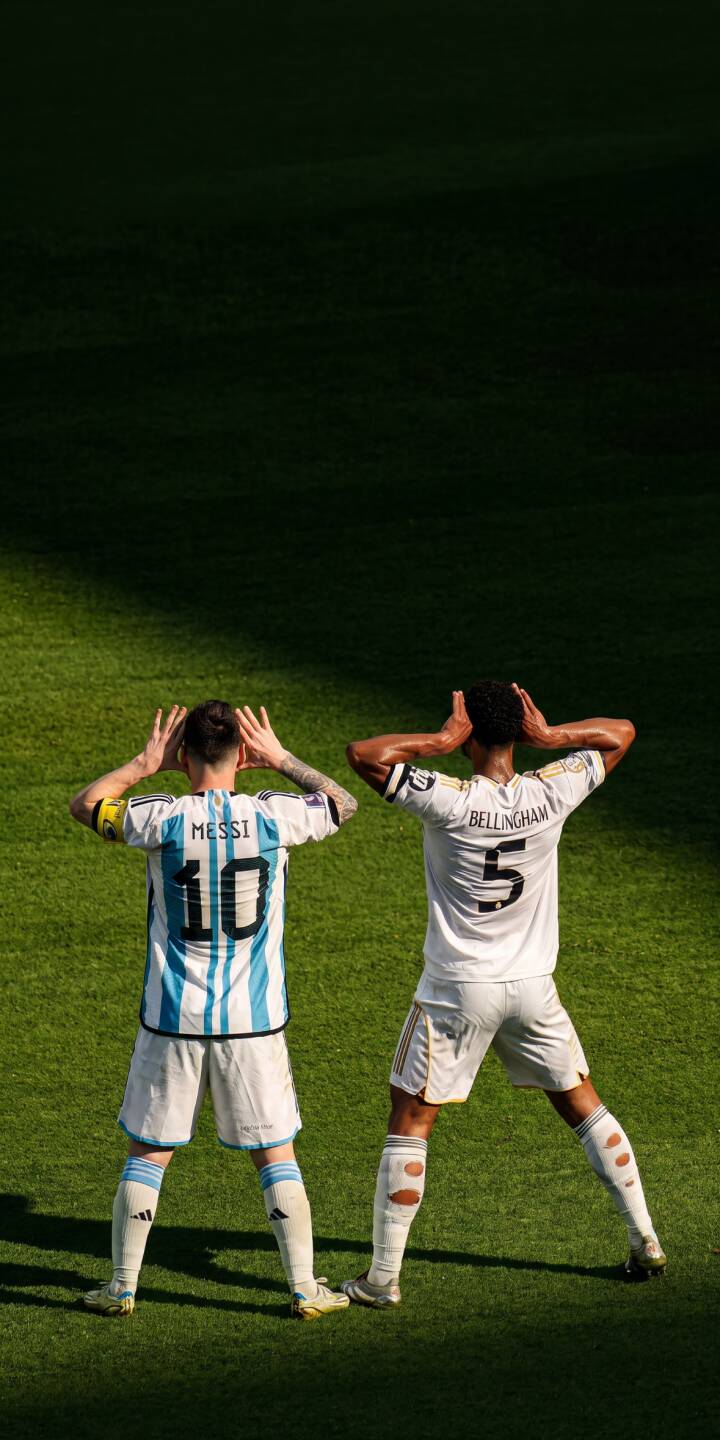 On a vibrant, sun-drenched pitch, Lionel Messi in his iconic Argentina #10 jersey and Jude Bellingham in his crisp white #5 kit stand side-by-side, both with hands behind their heads in a memorable gesture, making an incredible 4K wallpaper for your iPhone; download this dynamic football wallpaper now. | sports football iphone argentina soccer real madrid wallpaper jude bellingham lionel messi mobile 4k wallpaper hd wallpaper On a vibrant, sun-drenched pitch, Lionel Messi in his iconic Argentina #10 jersey and Jude Bellingham in his crisp white #5 kit stand side-by-side, both with hands behind their heads in a memorable gesture, making an incredible 4K wallpaper for your iPhone; download this dynamic football wallpaper now.