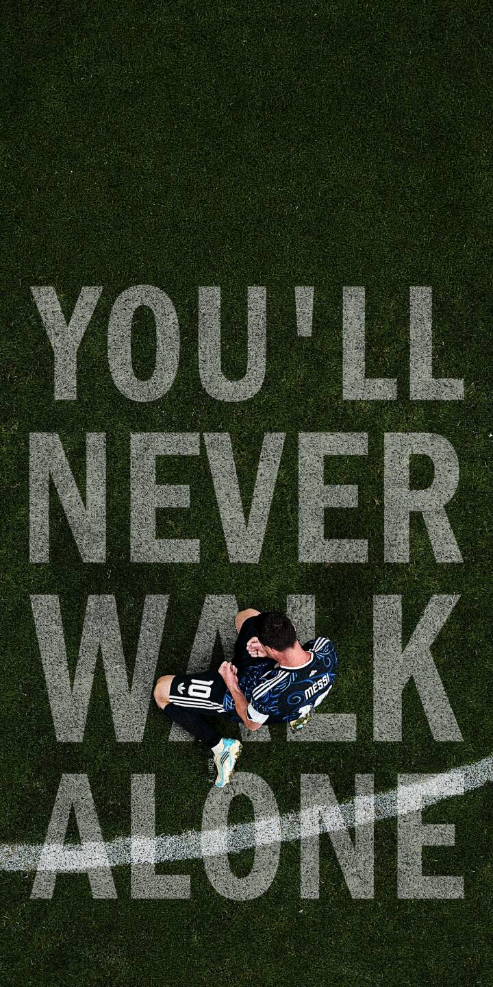 The powerful message 'YOU'LL NEVER WALK ALONE' is etched into the vibrant green football pitch beneath Lionel Messi, captured in this poignant 4K wallpaper. This emotional Messi wallpaper, showing the legendary star in his Argentina kit with a pensive expression, is an essential iPhone wallpaper. | football quote iphone messi argentina soccer wallpaper lionel messi mobile 4k wallpaper hd wallpaper inspirational The powerful message 'YOU'LL NEVER WALK ALONE' is etched into the vibrant green football pitch beneath Lionel Messi, captured in this poignant 4K wallpaper. This emotional Messi wallpaper, showing the legendary star in his Argentina kit with a pensive expression, is an essential iPhone wallpaper.