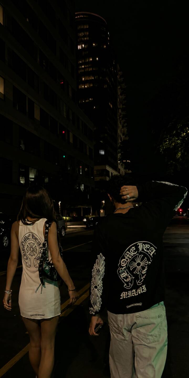 Chromehearts cross logos elegantly adorn the backs of two figures strolling through a dark, atmospheric city street in this stunning 4K wallpaper. This stylish mobile wallpaper is an ideal choice for iPhone users seeking an edgy urban aesthetic. | aesthetic urban dark night iphone wallpaper fashion mobile 4k wallpaper hd wallpaper streetwear chromehearts Chromehearts cross logos elegantly adorn the backs of two figures strolling through a dark, atmospheric city street in this stunning 4K wallpaper. This stylish mobile wallpaper is an ideal choice for iPhone users seeking an edgy urban aesthetic.