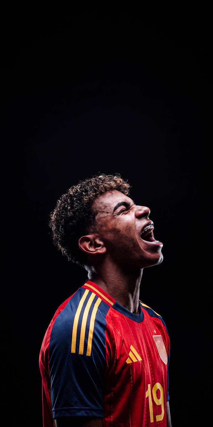 With an open-mouthed roar, a curly-haired soccer player in a vibrant Spain national team jersey (number 19 visible) passionately yells against a dramatic dark background in this powerful 4K wallpaper, making it an epic wallpaper for iPhone. | football player athlete iphone soccer spain wallpaper scream mobile 4k wallpaper hd wallpaper intense With an open-mouthed roar, a curly-haired soccer player in a vibrant Spain national team jersey (number 19 visible) passionately yells against a dramatic dark background in this powerful 4K wallpaper, making it an epic wallpaper for iPhone.