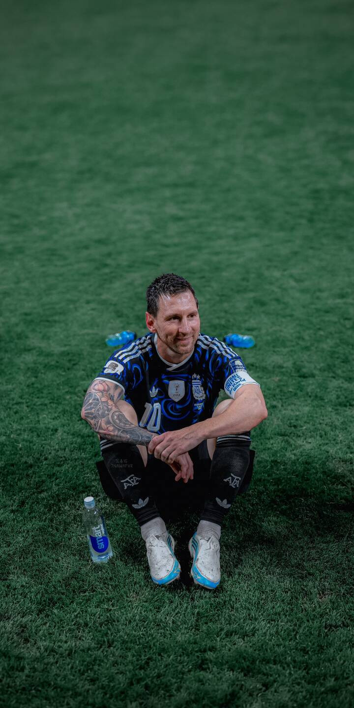 Messi's gentle smile graces his face as he sits on the lush green field, wearing his iconic Argentina jersey and showing off his arm tattoos in this captivating 4K wallpaper. This essential wallpaper for iPhone fans captures a moment of quiet reflection for the legendary player. | football athlete pitch iphone messi argentina soccer wallpaper lionel messi mobile 4k wallpaper hd wallpaper Messi's gentle smile graces his face as he sits on the lush green field, wearing his iconic Argentina jersey and showing off his arm tattoos in this captivating 4K wallpaper. This essential wallpaper for iPhone fans captures a moment of quiet reflection for the legendary player.