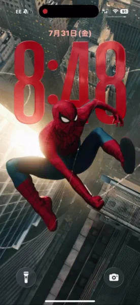 Caught mid-air with his iconic red and blue suit, Spider-Man swings high above a sprawling city skyline in this thrilling 4K wallpaper for iPhone.