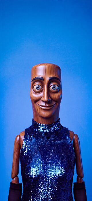 The unique character of a smiling wooden puppet is beautifully captured in this 4K double wallpaper for your iPhone. This aesthetic wallpaper features the puppet with open, serene eyes on the lock screen and closed, peaceful eyes on the home screen, all set against a vibrant blue background with its dazzling sequined attire.