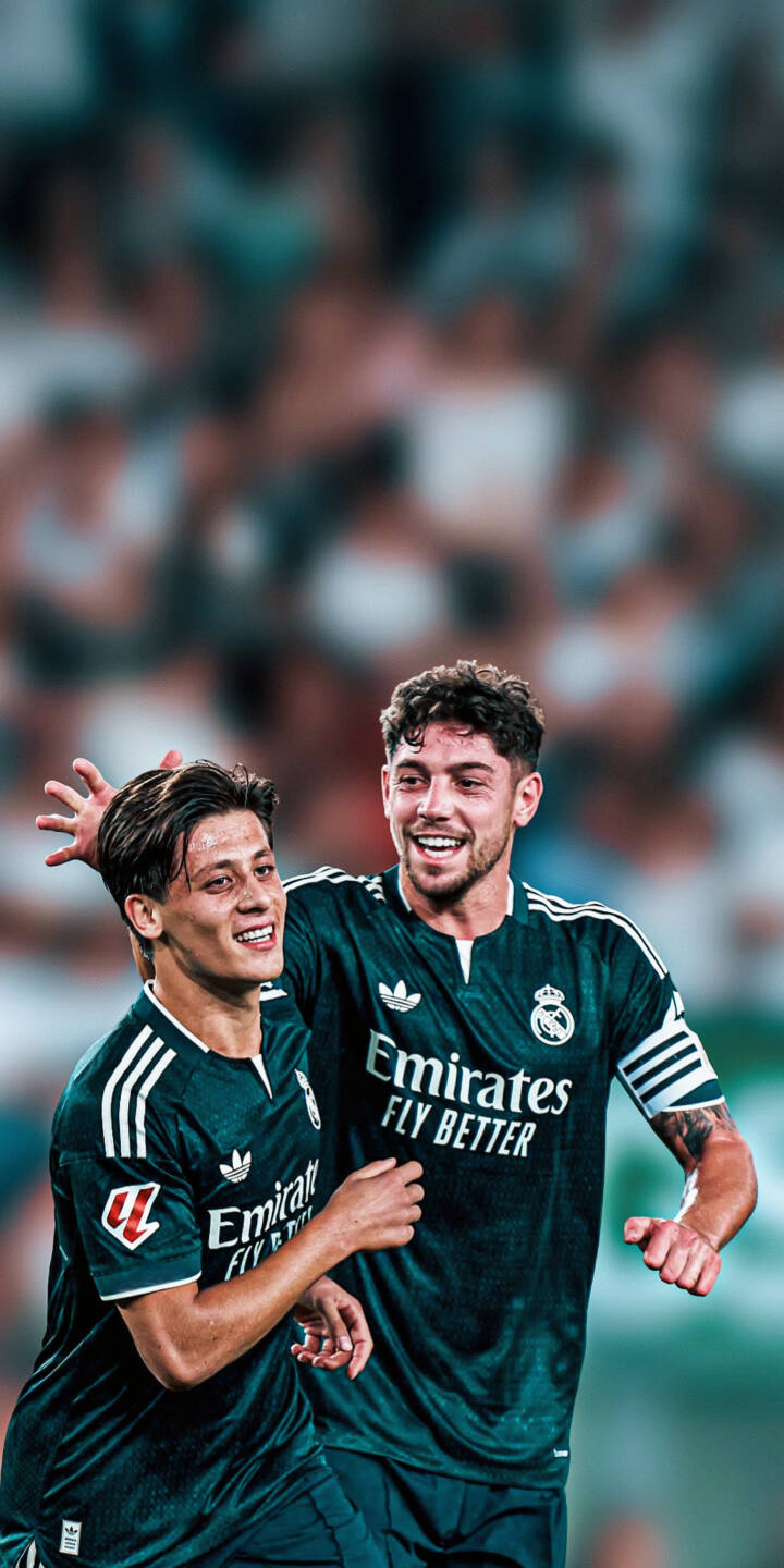 The joyous embrace of Real Madrid's Fede Valverde and his teammate radiates triumph in this stunning 4K wallpaper, featuring their distinctive dark green jerseys against a blurred stadium backdrop — a perfect wallpaper for iPhone. | sports football celebration iphone team real madrid wallpaper players mobile 4k wallpaper hd wallpaper valverde The joyous embrace of Real Madrid's Fede Valverde and his teammate radiates triumph in this stunning 4K wallpaper, featuring their distinctive dark green jerseys against a blurred stadium backdrop — a perfect wallpaper for iPhone.