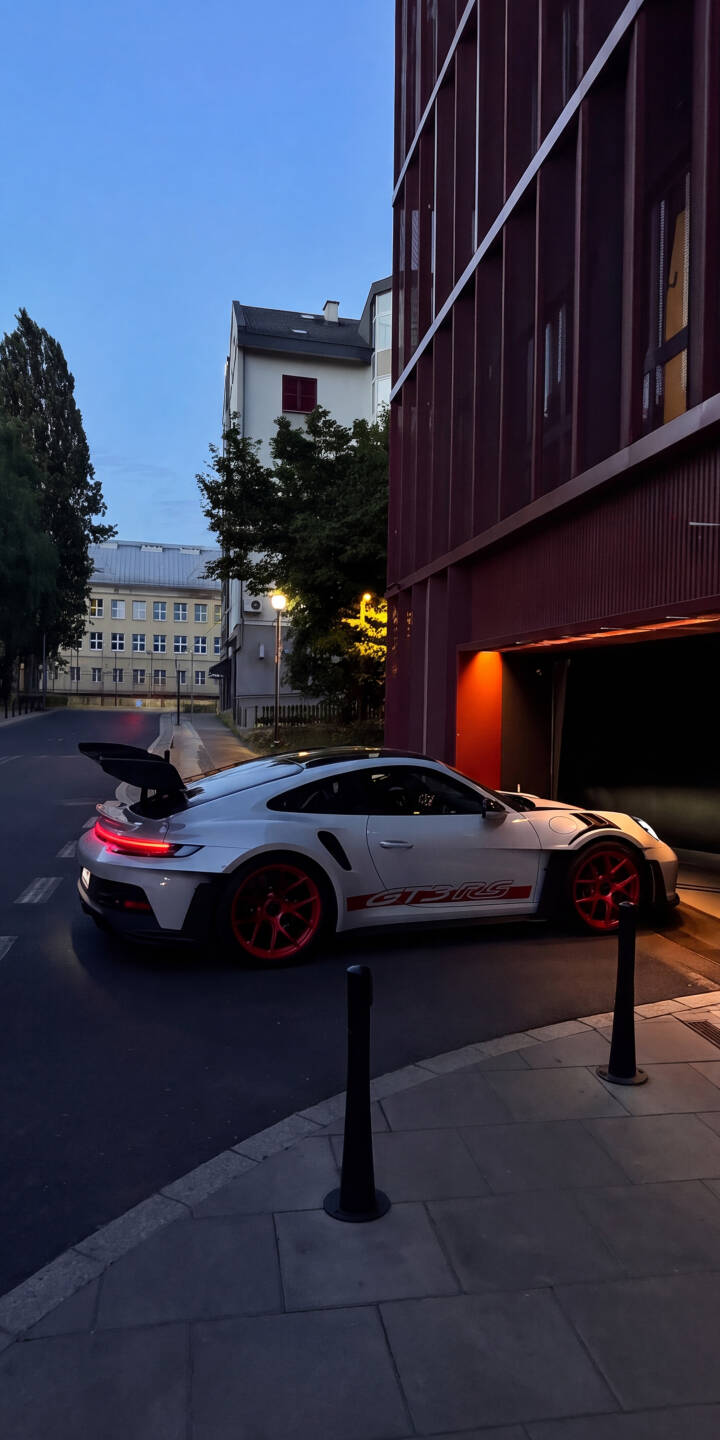 The sleek white Porsche GT3 RS, with its vibrant red wheels and prominent rear spoiler, emerges from an illuminated garage entrance in this stunning 4K wallpaper. This premium automotive wallpaper is perfect for personalizing your iPhone. | sports car urban iphone porsche wallpaper mobile porsche 911 gt3 rs 4k wallpaper hd wallpaper automotive red wheels The sleek white Porsche GT3 RS, with its vibrant red wheels and prominent rear spoiler, emerges from an illuminated garage entrance in this stunning 4K wallpaper. This premium automotive wallpaper is perfect for personalizing your iPhone.