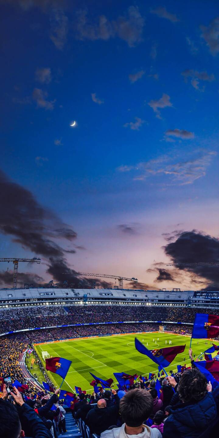 A serene crescent moon hangs over a vibrant football stadium where a passionate crowd waves blue and maroon flags under a beautiful twilight sky, making for an electrifying 4K wallpaper perfect for your iPhone. | football stadium crowd moon twilight iphone soccer wallpaper mobile 4k wallpaper hd wallpaper atmospheric A serene crescent moon hangs over a vibrant football stadium where a passionate crowd waves blue and maroon flags under a beautiful twilight sky, making for an electrifying 4K wallpaper perfect for your iPhone.
