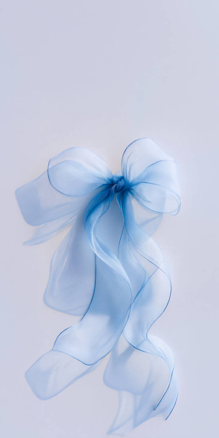 The translucent folds of a light blue ribbon form an elegantly tied bow, with long, flowing ends creating a serene atmosphere in this stunning 4K wallpaper. This delicate ribbon wallpaper is a beautiful choice for any iPhone, adding a touch of gentle calm to your screen. | aesthetic bow iphone minimalist wallpaper pastel mobile elegant light blue 4k wallpaper hd wallpaper blue ribbon The translucent folds of a light blue ribbon form an elegantly tied bow, with long, flowing ends creating a serene atmosphere in this stunning 4K wallpaper. This delicate ribbon wallpaper is a beautiful choice for any iPhone, adding a touch of gentle calm to your screen.
