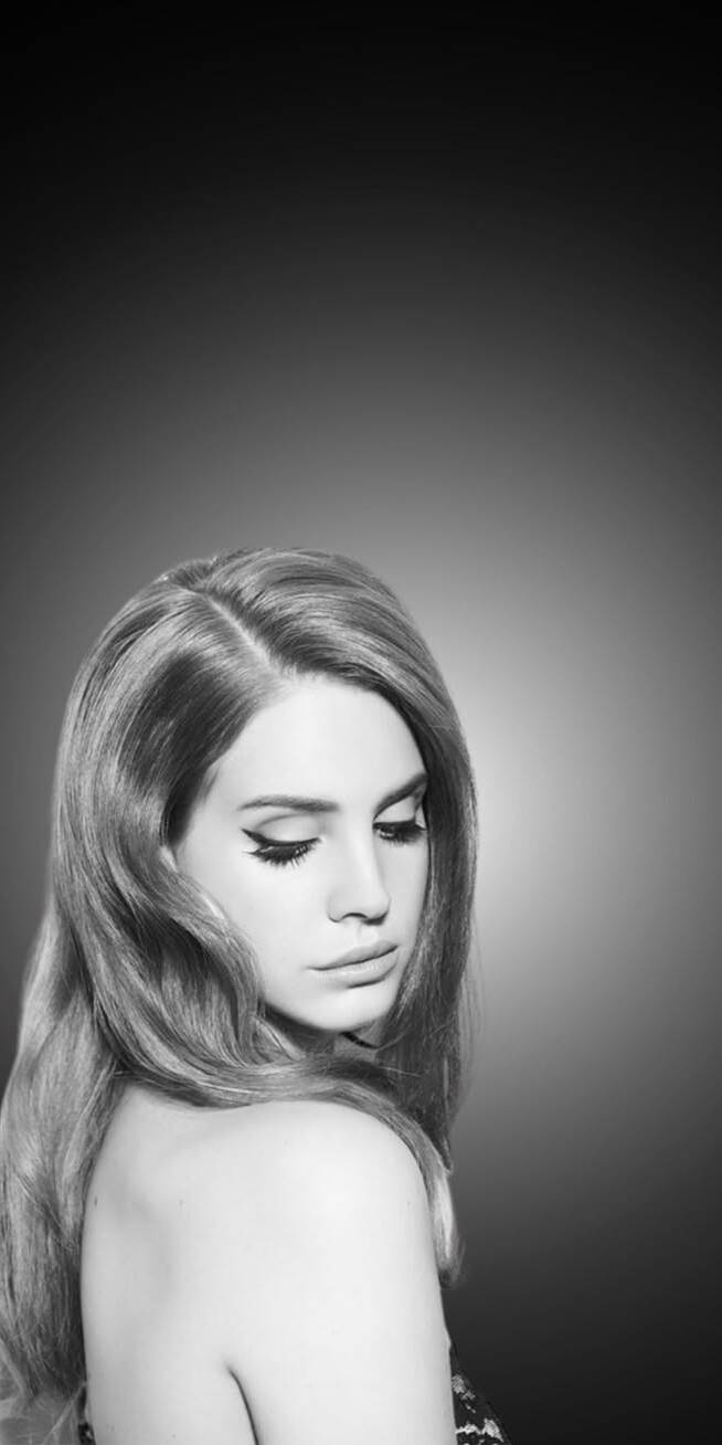 Her elegant winged eyeliner defines a subtle downward gaze as Lana Del Rey's signature wavy hair frames her face in this stunning 4K grayscale wallpaper. This pensive and iconic portrait creates a perfect atmospheric wallpaper for your iPhone. | cute halloween aesthetic lana del rey Her elegant winged eyeliner defines a subtle downward gaze as Lana Del Rey's signature wavy hair frames her face in this stunning 4K grayscale wallpaper. This pensive and iconic portrait creates a perfect atmospheric wallpaper for your iPhone.