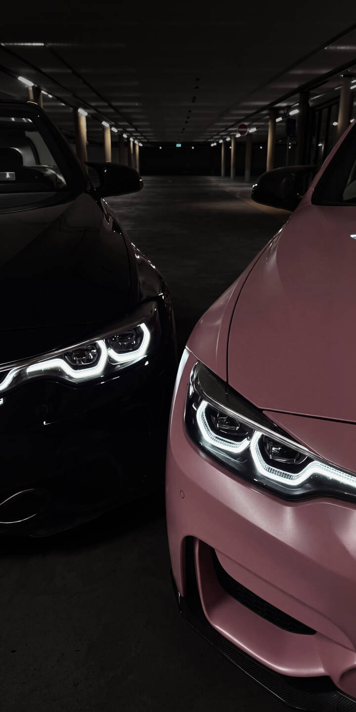 The sleek contrast of a black and a unique pink sports car, illuminated by their sharp glowing headlights, creates a powerful 4K automotive wallpaper perfect for iPhone. This detailed image captures the modern aesthetics of powerful vehicles in a dark, atmospheric garage setting. | car garage iphone bmw wallpaper black car mobile headlights pink car 4k wallpaper hd wallpaper automotive The sleek contrast of a black and a unique pink sports car, illuminated by their sharp glowing headlights, creates a powerful 4K automotive wallpaper perfect for iPhone. This detailed image captures the modern aesthetics of powerful vehicles in a dark, atmospheric garage setting.