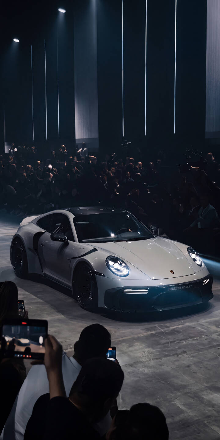Bright spotlights illuminate the pristine white Porsche 911, showcasing its sleek design amidst a captivated audience in this stunning 4K wallpaper. This dynamic automotive wallpaper for iPhone captures the thrill of a modern car launch. | iphone porsche wallpaper modern sportscar mobile luxury car porsche 911 4k wallpaper hd wallpaper automotive sleek Bright spotlights illuminate the pristine white Porsche 911, showcasing its sleek design amidst a captivated audience in this stunning 4K wallpaper. This dynamic automotive wallpaper for iPhone captures the thrill of a modern car launch.