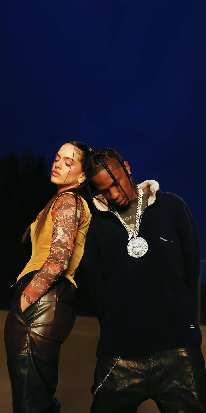 Rosalia and Travis Scott lean stylishly back-to-back, their matching leather pants and unique accessories perfectly showcased in this vibrant 4K wallpaper. This stunning celebrity duo wallpaper is an essential download for iPhone users looking for a sleek, high-fashion aesthetic. | artist Rosalia and Travis Scott lean stylishly back-to-back, their matching leather pants and unique accessories perfectly showcased in this vibrant 4K wallpaper. This stunning celebrity duo wallpaper is an essential download for iPhone users looking for a sleek, high-fashion aesthetic.