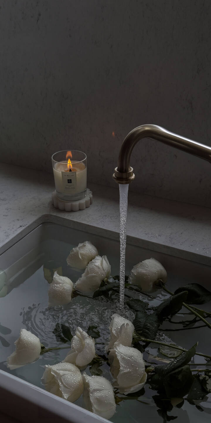 A clear stream of water cascades into a sink filled with delicate white rosebuds, their petals glistening with droplets in this serene 4K wallpaper — an elegant wallpaper choice for iPhone users. | aesthetic flowers water candle iphone wallpaper mobile roses moody 4k wallpaper hd wallpaper white roses A clear stream of water cascades into a sink filled with delicate white rosebuds, their petals glistening with droplets in this serene 4K wallpaper — an elegant wallpaper choice for iPhone users.